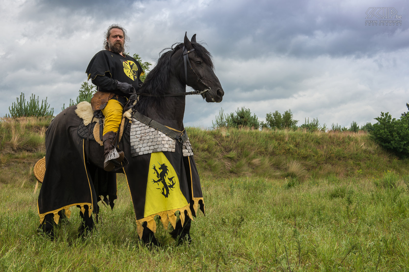 Historia Mundi - Knight In June the Historia Mundi event took place in Lommel. During two days many groups came together to do re-enacting and living history. Based on historical research all groups tried to reproduce cloths, weapons, tents, crafts, ... Many of these people know their piece of history very detailed and are very enthusiastic when telling about it. I made a series of photos of prehistoric people, Romans, medieval knights, soldiers from the Renaissance, Scottish Highlanders, German soldiers from WWI, ... Stefan Cruysberghs